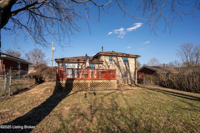 rear view of house featuring fence, a lawn, and a wooden deck