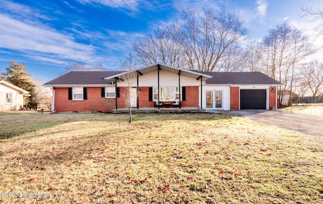 ranch-style house with brick siding, aphalt driveway, an attached garage, fence, and a front yard