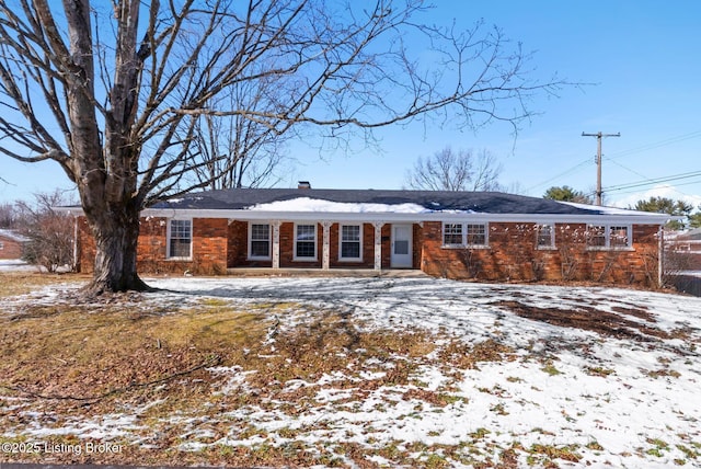 single story home with brick siding and a chimney