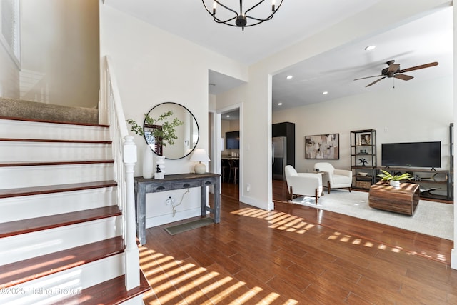 foyer entrance with recessed lighting, baseboards, dark wood-type flooring, stairs, and ceiling fan with notable chandelier