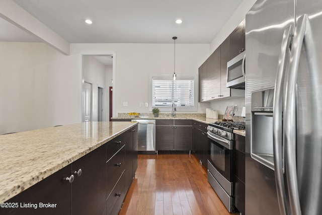 kitchen featuring dark wood-style flooring, recessed lighting, hanging light fixtures, appliances with stainless steel finishes, and a sink