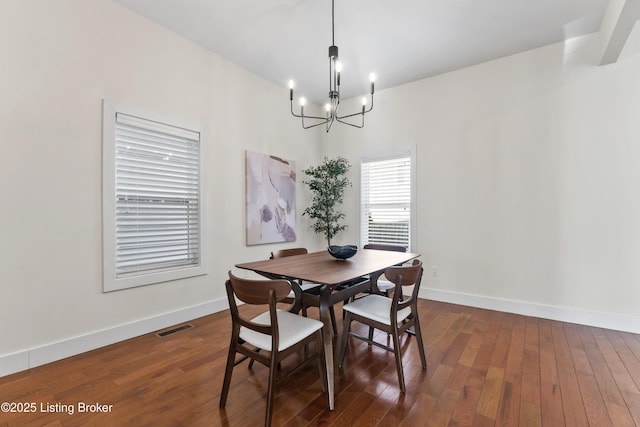 dining space featuring an inviting chandelier, baseboards, visible vents, and dark wood-style flooring