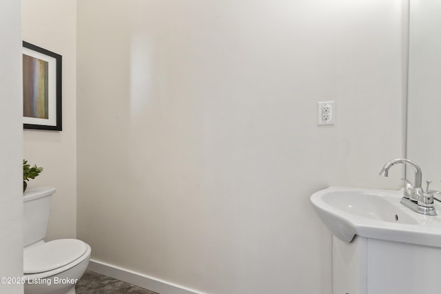 bathroom with baseboards, vanity, and toilet