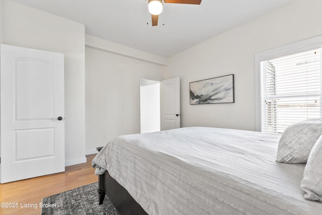 bedroom with wood finished floors, a ceiling fan, and baseboards