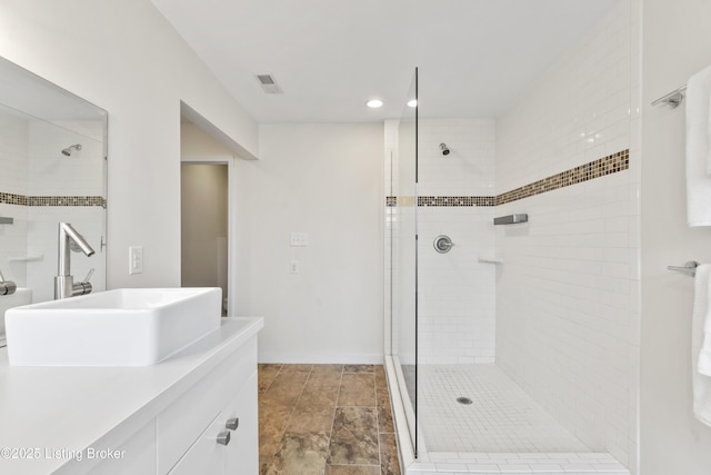 full bathroom with a stall shower, visible vents, and vanity