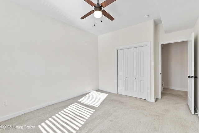 unfurnished bedroom with baseboards, a closet, a ceiling fan, and light colored carpet