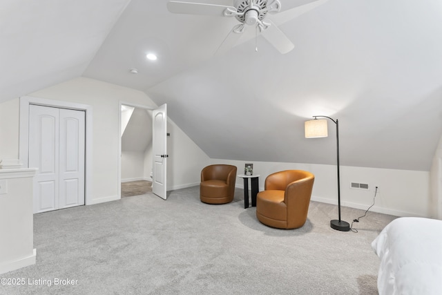 living area featuring light carpet, visible vents, baseboards, a ceiling fan, and vaulted ceiling