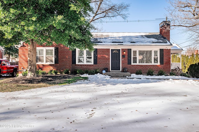 bungalow-style house featuring a chimney and brick siding