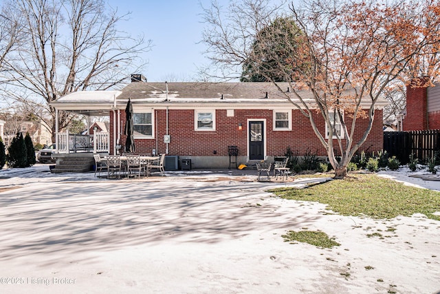 back of property with brick siding, a chimney, a patio area, and fence