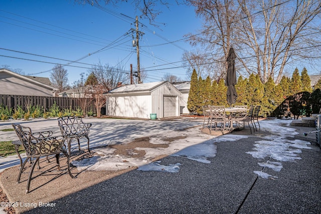 view of yard featuring a garage, a patio area, fence, and an outdoor structure