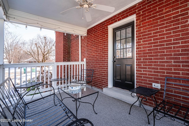 doorway to property featuring brick siding and a ceiling fan