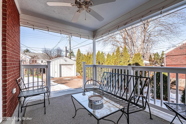 view of patio / terrace featuring ceiling fan, an outdoor structure, and a garage