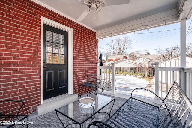 exterior space featuring fence, a ceiling fan, and brick siding