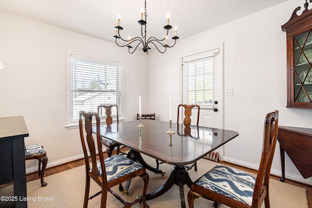 dining area with an inviting chandelier, baseboards, and wood finished floors