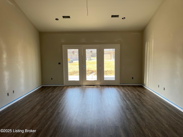 spare room with visible vents, dark wood finished floors, and baseboards