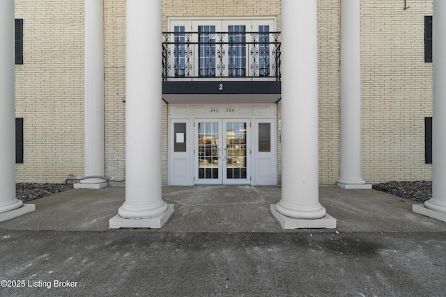 property entrance featuring a balcony and french doors