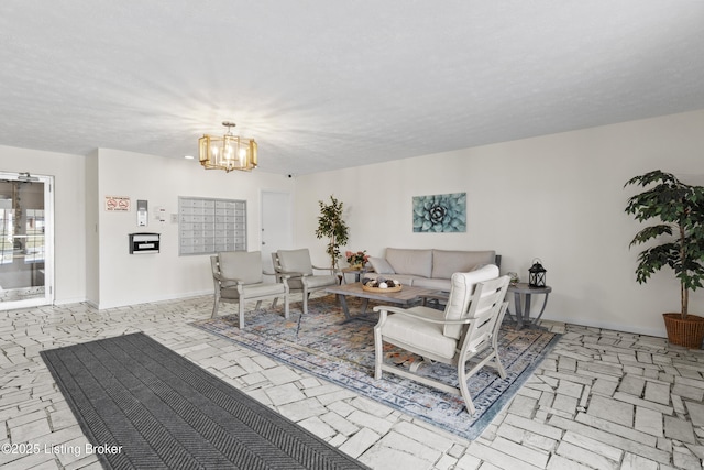 living room featuring a notable chandelier, a textured ceiling, mail area, and baseboards