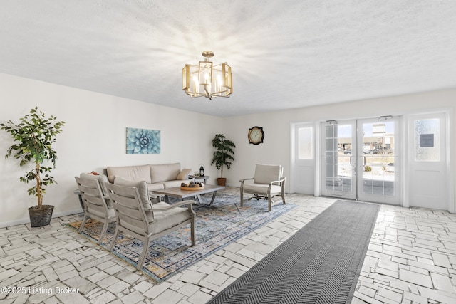 living area featuring a textured ceiling, french doors, baseboards, and a notable chandelier