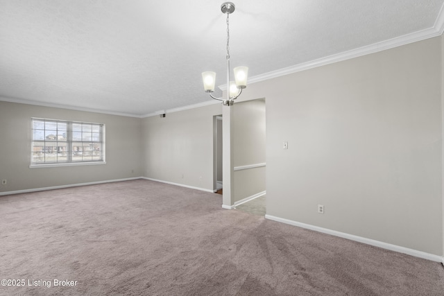 carpeted spare room with baseboards, a textured ceiling, ornamental molding, and a notable chandelier