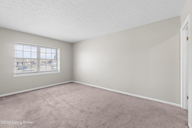 carpeted empty room featuring baseboards and a textured ceiling