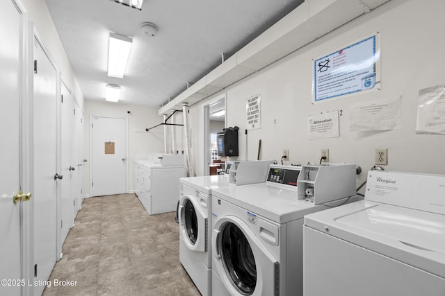 community laundry room with a textured ceiling and washing machine and clothes dryer