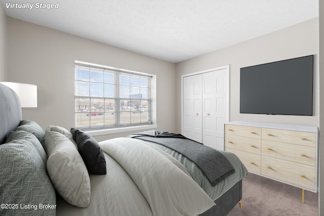 bedroom featuring a textured ceiling, dark colored carpet, and a closet