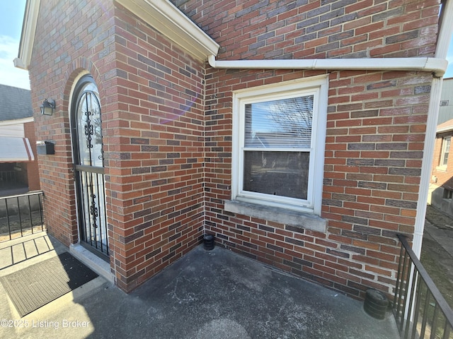 view of exterior entry featuring brick siding