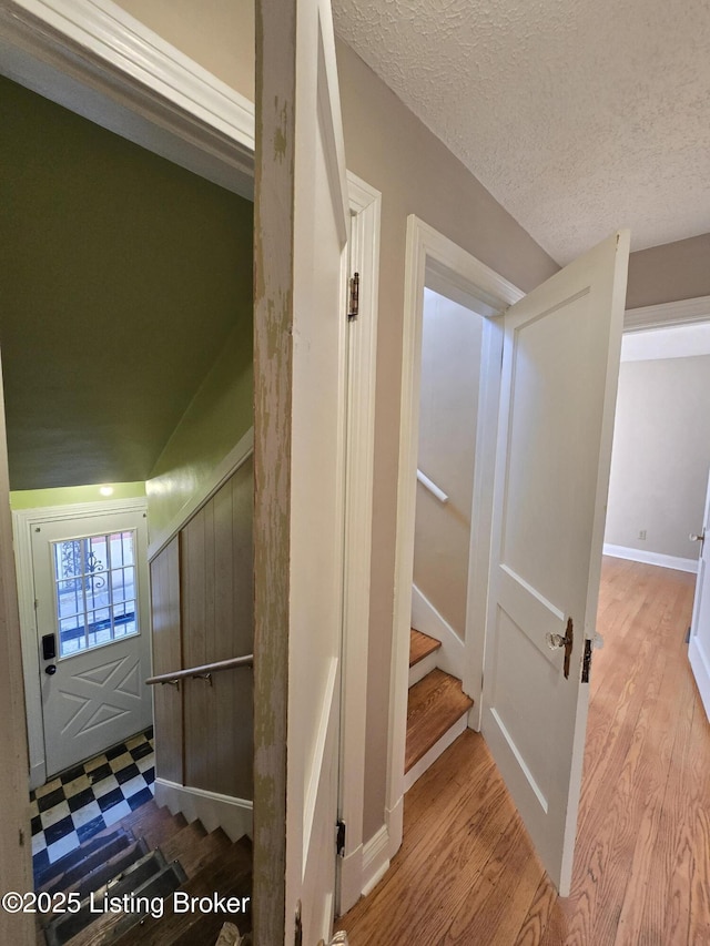 interior space featuring stairway, light floors, and a textured ceiling