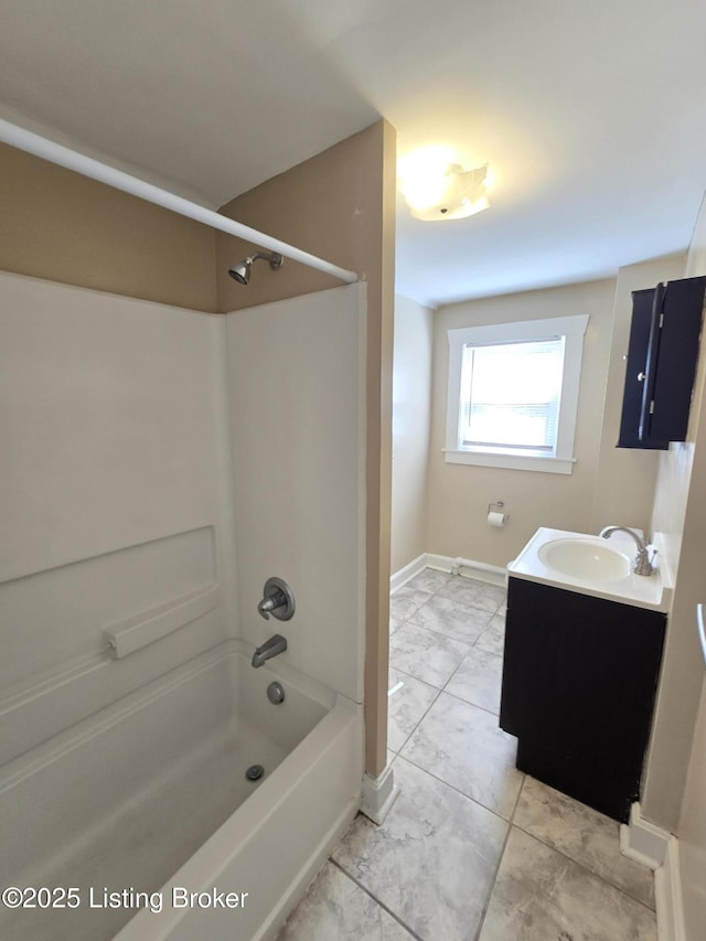 full bathroom featuring  shower combination, marble finish floor, vanity, and baseboards