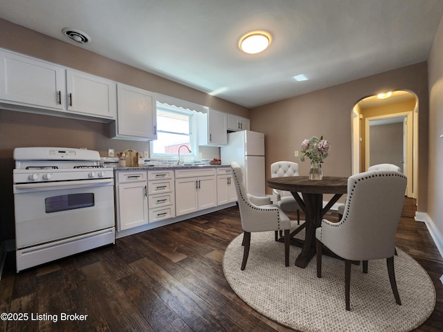 kitchen featuring white appliances, white cabinets, dark wood finished floors, and visible vents