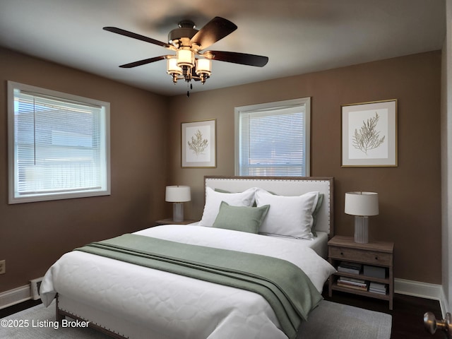 bedroom featuring multiple windows, baseboards, and a ceiling fan