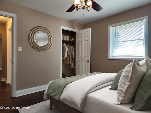 bedroom featuring a closet, dark wood finished floors, baseboards, and ceiling fan