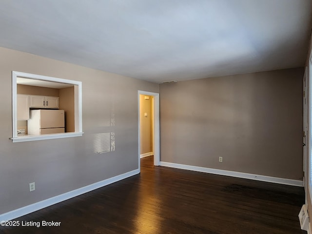 unfurnished room featuring dark wood finished floors and baseboards