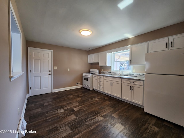 kitchen with dark wood-type flooring, white cabinets, a sink, white appliances, and baseboards