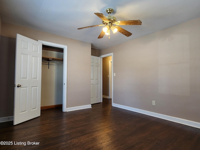 unfurnished bedroom with ceiling fan, a closet, baseboards, and dark wood-type flooring