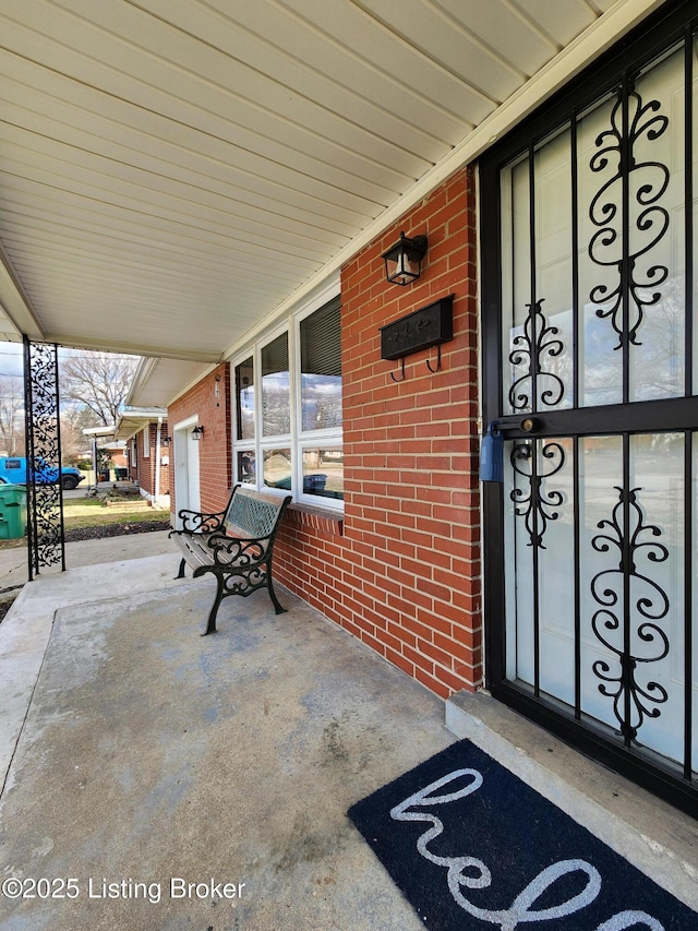 exterior space featuring a porch and brick siding