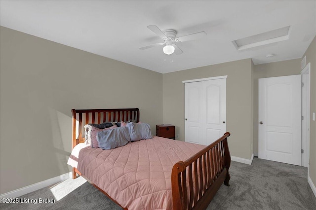 carpeted bedroom featuring a ceiling fan, a closet, attic access, and baseboards