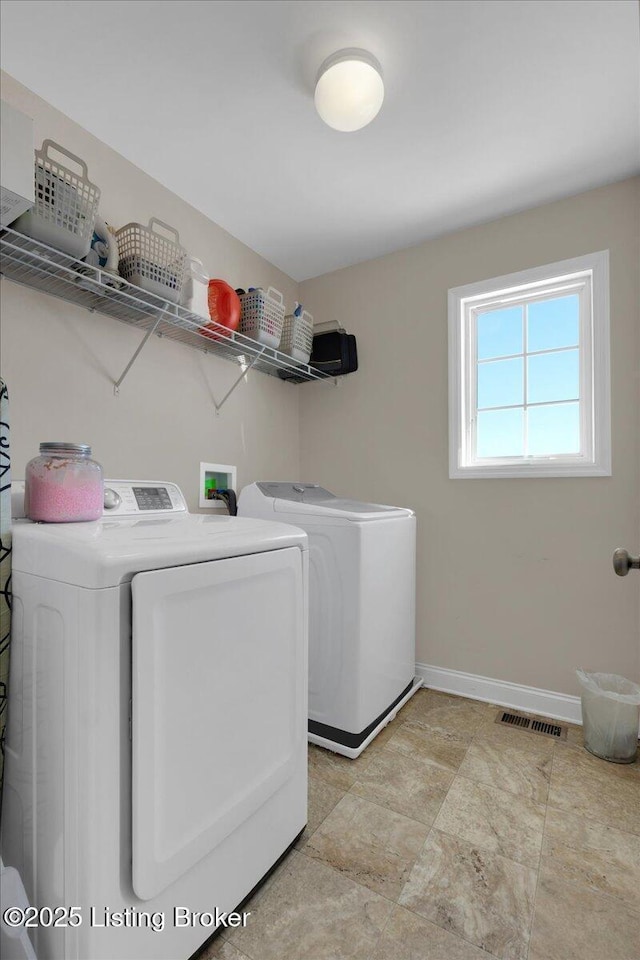 clothes washing area with laundry area, baseboards, visible vents, and separate washer and dryer