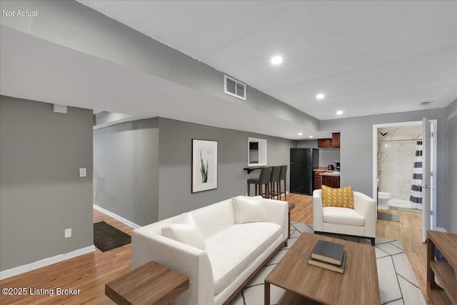 living area featuring light wood-style floors, recessed lighting, visible vents, and baseboards