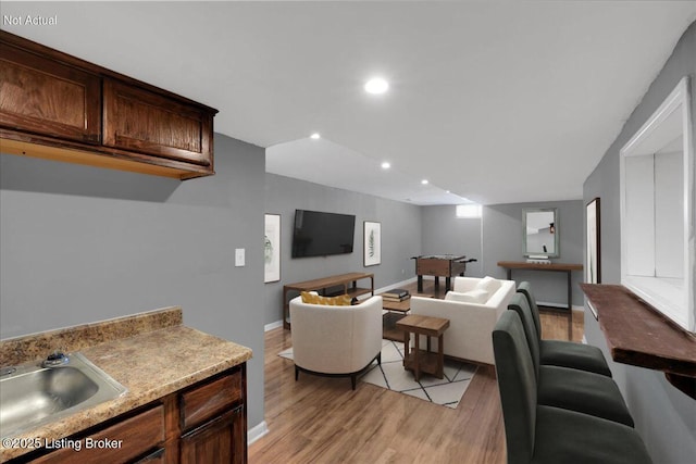 living room with light wood-type flooring, baseboards, and recessed lighting