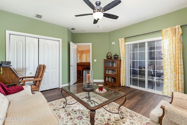 living area with visible vents, baseboards, and wood finished floors