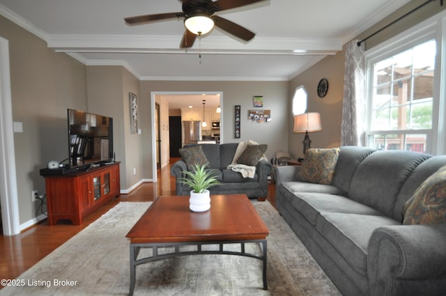 living area with ceiling fan, crown molding, baseboards, and wood finished floors