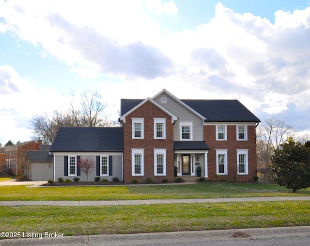 view of front facade with brick siding and a front yard