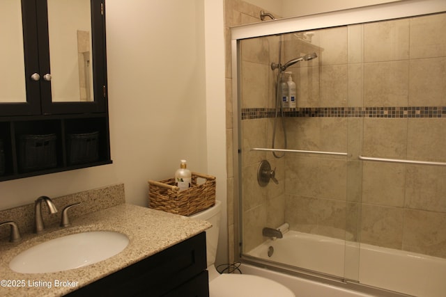 full bathroom featuring combined bath / shower with glass door, vanity, and toilet