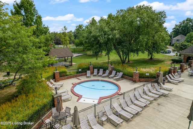 pool with a patio area, fence, and a lawn