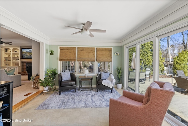 sunroom / solarium with a brick fireplace and a ceiling fan