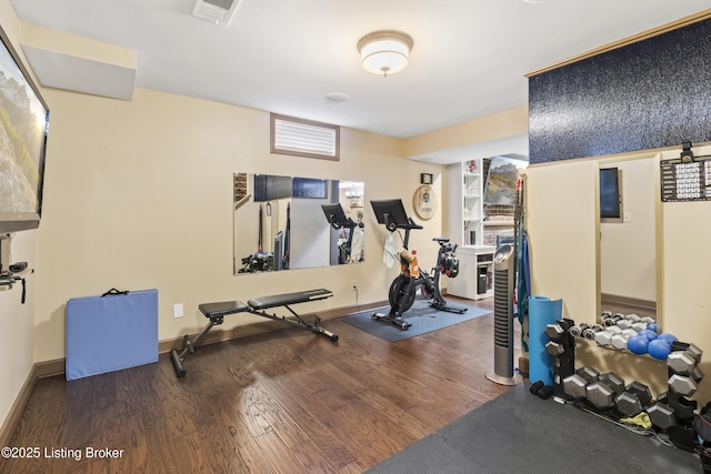 exercise room featuring visible vents, baseboards, and wood finished floors