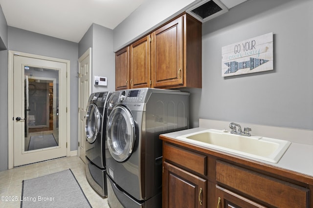 laundry room with light tile patterned floors, separate washer and dryer, a sink, visible vents, and cabinet space