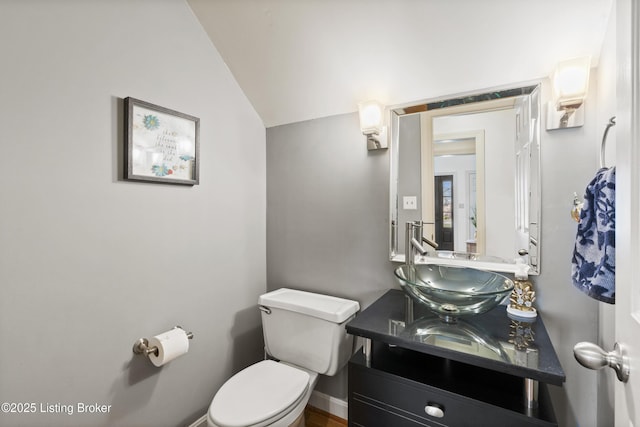 bathroom featuring vaulted ceiling, vanity, and toilet