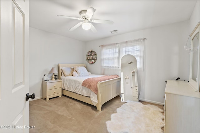 bedroom featuring a ceiling fan, light carpet, visible vents, and baseboards